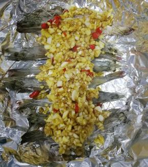 将蒜蓉酱用勺子铺在虾尾上