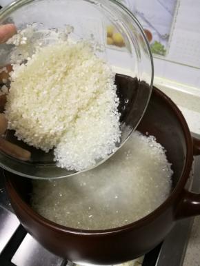 浸泡好的米入砂锅，加水，水超过大米平面的一厘米，往砂锅里加入一点食用油和盐，能使米饭颗颗分明，油光发亮更有嚼劲，也能防止米饭粘锅，盖上盖子，大火煮开后，转小火