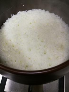 待米饭煮至锅内已无水冒泡后，放入切成片的腊肠，继续小火焖