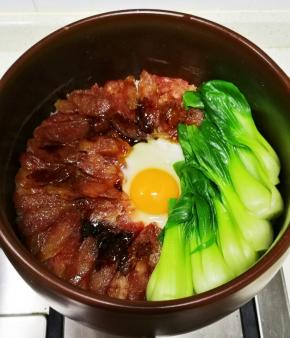腊肠八成熟的时候，沿着锅边倒入少许食用油，这是起锅巴的秘诀，在米饭中间打上1个鸡蛋，继续小火焖