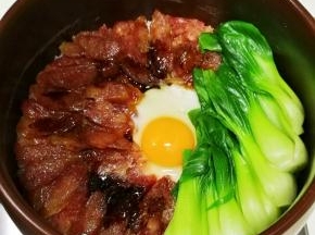 腊肠八成熟的时候，沿着锅边倒入少许食用油，这是起锅巴的秘诀，在米饭中间打上1个鸡蛋，继续小火焖