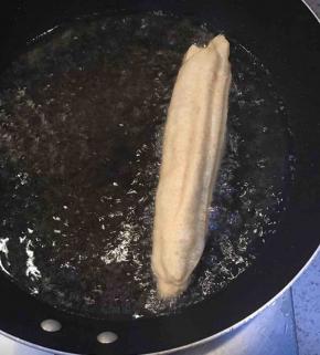  油锅烧热，把面拿起来稍微拉长些，放进去，如果油温合适，放进去后就会漂上来。