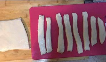 将面团擀至一厘米厚的长条，面团弹性太好了，切的时候已然不太听话变成很宽了，没关系反正一会儿也要拉长~