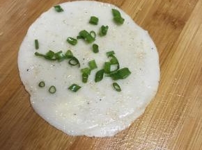 盖上一张饺子皮，抹上盐和椒盐粉，撒上葱末。