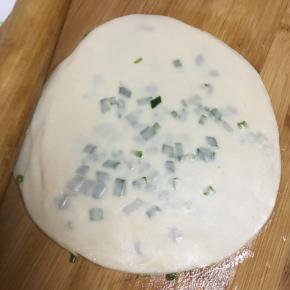 最后再盖上一张饺子皮，用擀面棍擀薄。