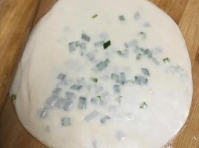 最后再盖上一张饺子皮，用擀面棍擀薄。