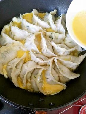 水收干，饺子周围淋上搅好的鸡蛋液，
