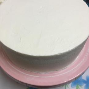 盖上另一片蛋糕片，在蛋糕表面和周边都抹上奶油。