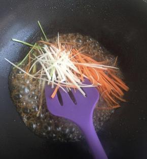 倒入香菜梗，胡萝卜丝，葱丝，翻炒。