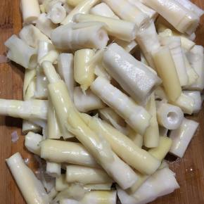 春笋去壳洗净，加入清水煮熟，放入冷水中浸泡过夜去涩味，捞出沥干切段。