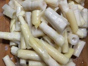 春笋去壳洗净，加入清水煮熟，放入冷水中浸泡过夜去涩味，捞出沥干切段。