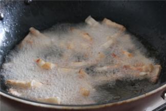 锅内倒入多点的油，油温5成热的时候放入肉丁小火炸至外表金黄