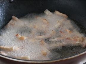 锅内倒入多点的油，油温5成热的时候放入肉丁小火炸至外表金黄