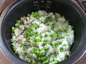 4、等到水快干的时候放入炒好的豌豆拌匀。然后让它继续完成煮饭功能。