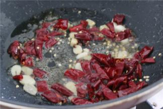 锅内留底油，依次放入姜蒜，花椒，干辣椒段翻炒出香味