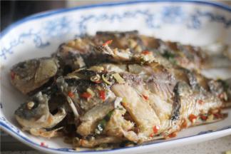 鱼煮熟后捞起放入盘中；可用筷子戳鱼，能戳烂鱼肉表示鱼熟了