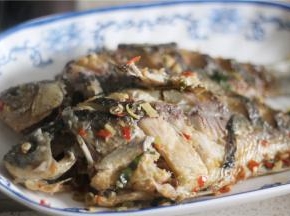 鱼煮熟后捞起放入盘中；可用筷子戳鱼，能戳烂鱼肉表示鱼熟了