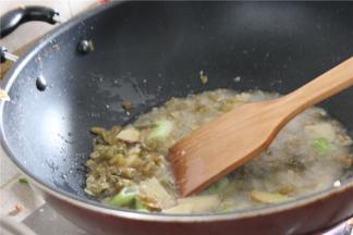 锅内倒油，放入切好的底料翻炒出香味