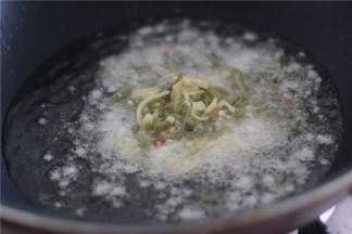 锅内留底油，油热之后依次放入蒜末、泡姜、泡豇豆，炒出香味