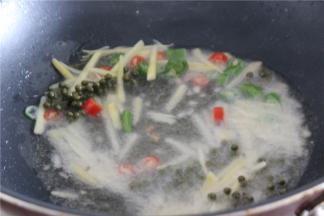 锅内烧热油，油热之后放入仔姜丝，青花椒和青红椒圈大火炒1分钟，炒出香味