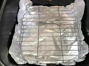 3、炸锅的内锅铺上锡纸，放入烤架。