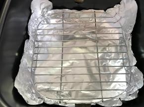 3、炸锅的内锅铺上锡纸，放入烤架。