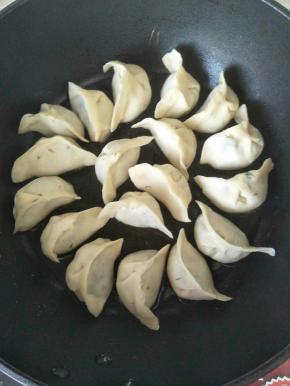 坐热平底锅，放适量油，开小火，把冻饺子码上去，小火煎2分钟。