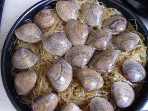 将蒜蓉粉丝铺在烤盘下面，上面放花甲，之后用锡纸包上