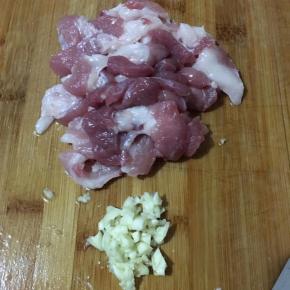 前腿肉切薄片，蒜头切碎。