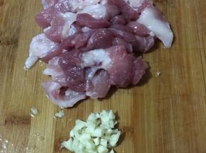 前腿肉切薄片，蒜头切碎。