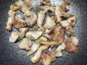 锅中加入少许油，下入肉片中火煸炒至出油表面微焦。