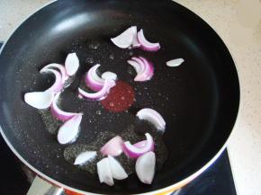 开始炒菜：锅里放入适量的食用油，倒入洋葱翻炒煸香。