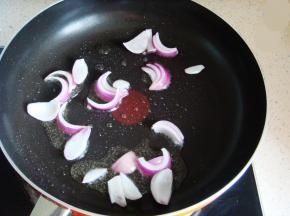 开始炒菜：锅里放入适量的食用油，倒入洋葱翻炒煸香。