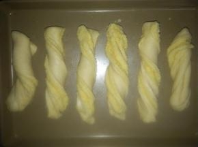 左手捏住面团一端，右手捏住另一端团转两圈，放烤盘（非不粘铺油纸）；