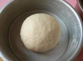 发酵好的面团取出按压排气，滚圆，放入抹了黄油（份量外，提前软化）的模具中