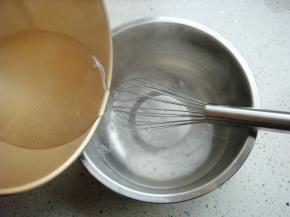 开水倒入白凉粉盆中，边倒边搅拌。