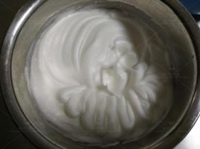 蛋清中分次加入细砂糖，用电动打蛋器打至湿性发泡。