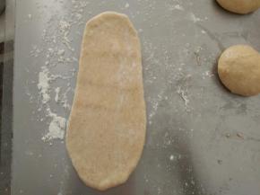 松驰好的面团分别擀成牛状，从上往下卷起。松驰15分钟后，再重复一次擀卷动作。