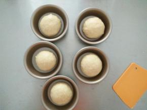 醒发好的面团再次排气揉圆，摆进汉堡模具中进行二次发酵。