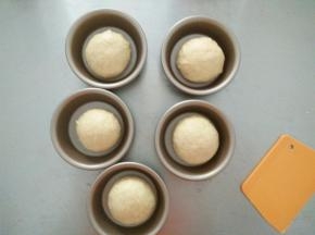 醒发好的面团再次排气揉圆，摆进汉堡模具中进行二次发酵。