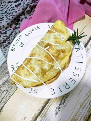 一边放上炒好的米饭，另一边折过来，撒上沙拉酱或者番茄酱开吃。