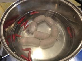 锅内烧水，加入几个干辣椒，然后喜欢颜色深的再加点老抽，用小火煮，今天罐装的肠很粗，时间要长些，最小火，不能咕嘟咕嘟开锅，否则容易爆开，煮20分钟。