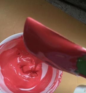 刚打好的蛋白糖霜适合裱花。但是底色抹面太干燥了，需要加水，调稀至如图状态，分出来一小部分打好的糖霜，一点点加水和色素，我做的有白底的，有红底的，就调了两个。