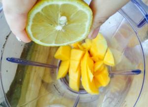 准备料理机，打磨机也行，芒果肉放入，挤一点柠檬汁