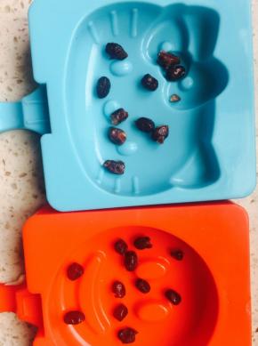 冰棍盒底放几粒蜜红豆，放点奶液，再放几颗蜜红豆，再放奶液。