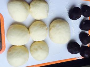 去除面团，排气，首先分出6个60克的面团，揉匀，然后剩下的面揉成团，盖保鲜膜醒面20分钟， 准备6个豆沙球，每个球40克