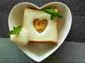 扣出爱心的土司片也抹上一层果酱，盖在煎蛋上，搞定。摆个poss~