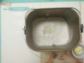 除黄油外的材料放入面包桶，启动揉面程序，揉成团后加入黄油。