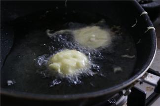 油温烧至七成热时，将茄饼放入调制好的面糊中裹上面糊，放入茄饼