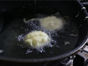 油温烧至七成热时，将茄饼放入调制好的面糊中裹上面糊，放入茄饼